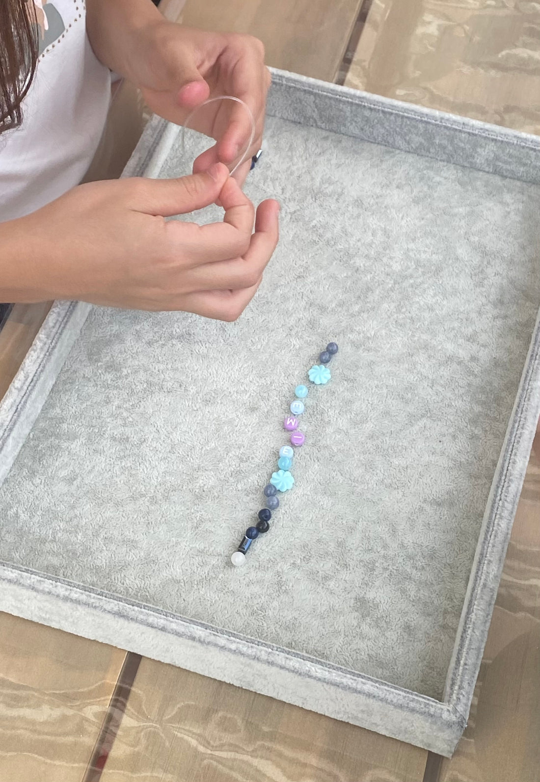 Enfant créant un bracelet de perles