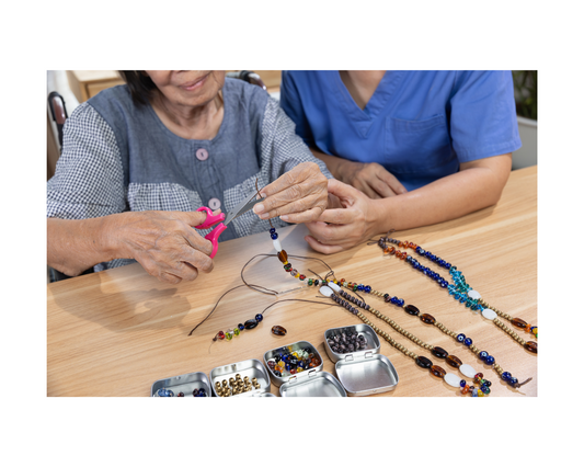 Personne âgée qui fabrique des bijoux.